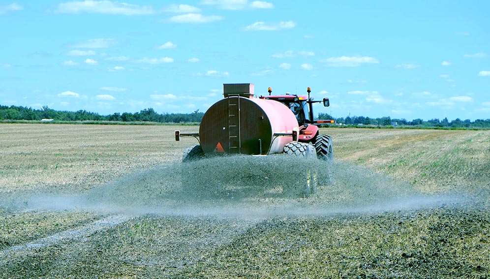 A picture of a truck spraying fertiliser. With proper techniques famerers can be able to reduce their fertiliser costs.